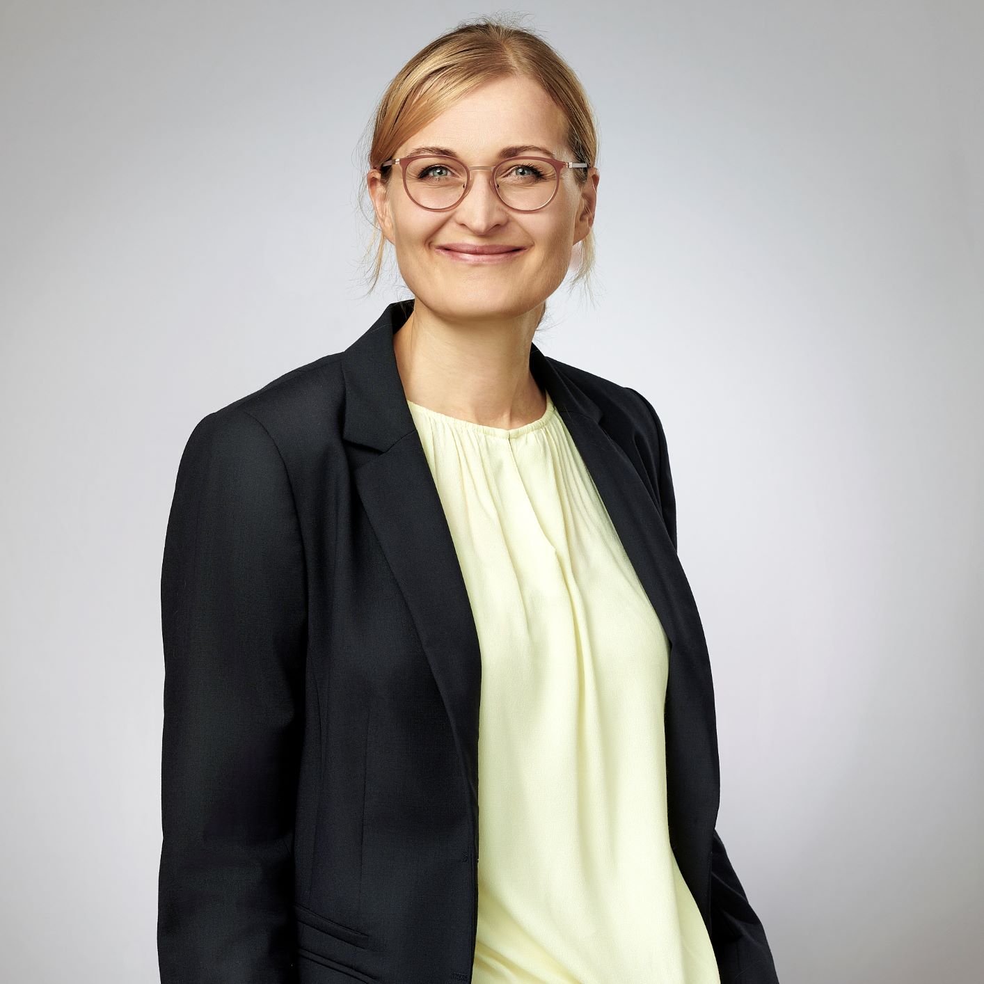 Silke Bühlt steht etwas weiter entfernt und lächelt in die Kamera.